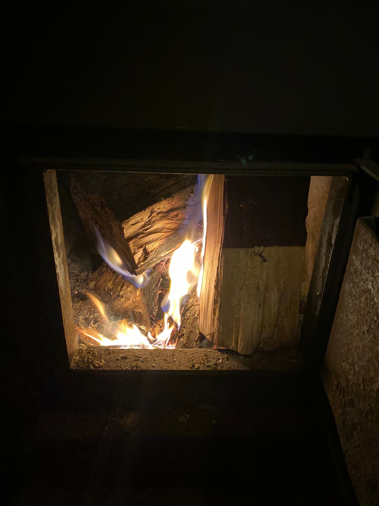 Wood-fired stove firebox glowing inside the banya
